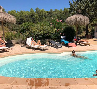 piscine bleu avec des personnes autour sur des transats et dans l'eau en été
