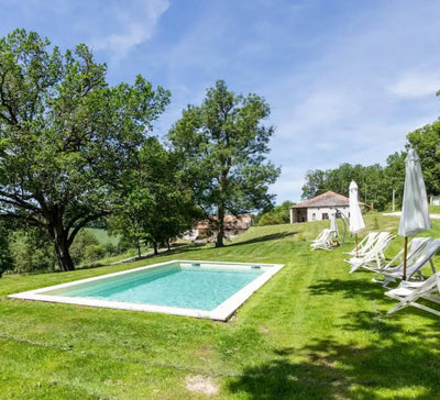 jardin avec piscine et transat avec parasol plié