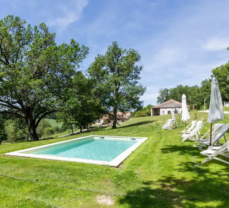jardin avec piscine et transat avec parasol plié